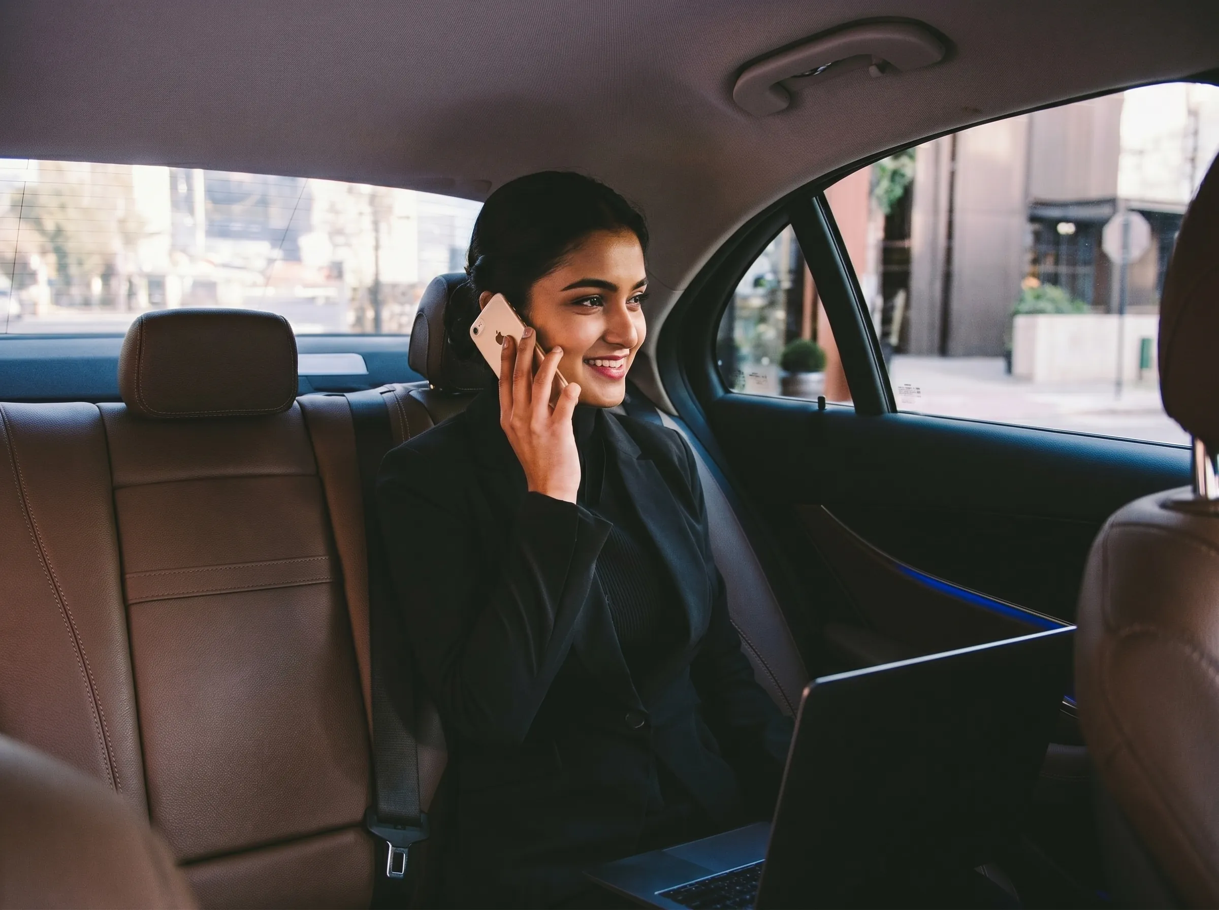 Passenger taking a call in the back of a car